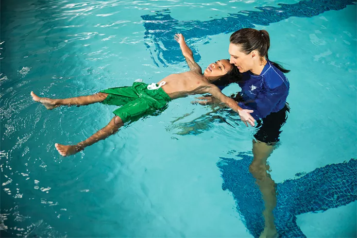 Boy learning how to float on his back