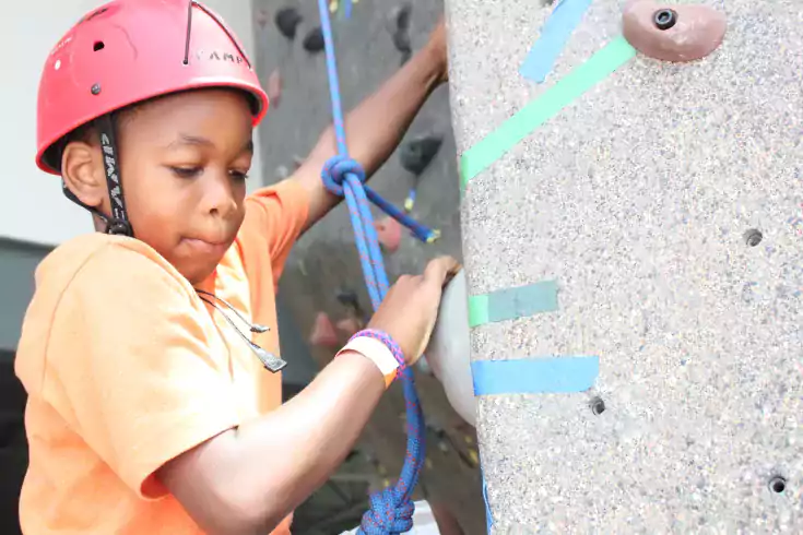 Boy climbing a rock wall